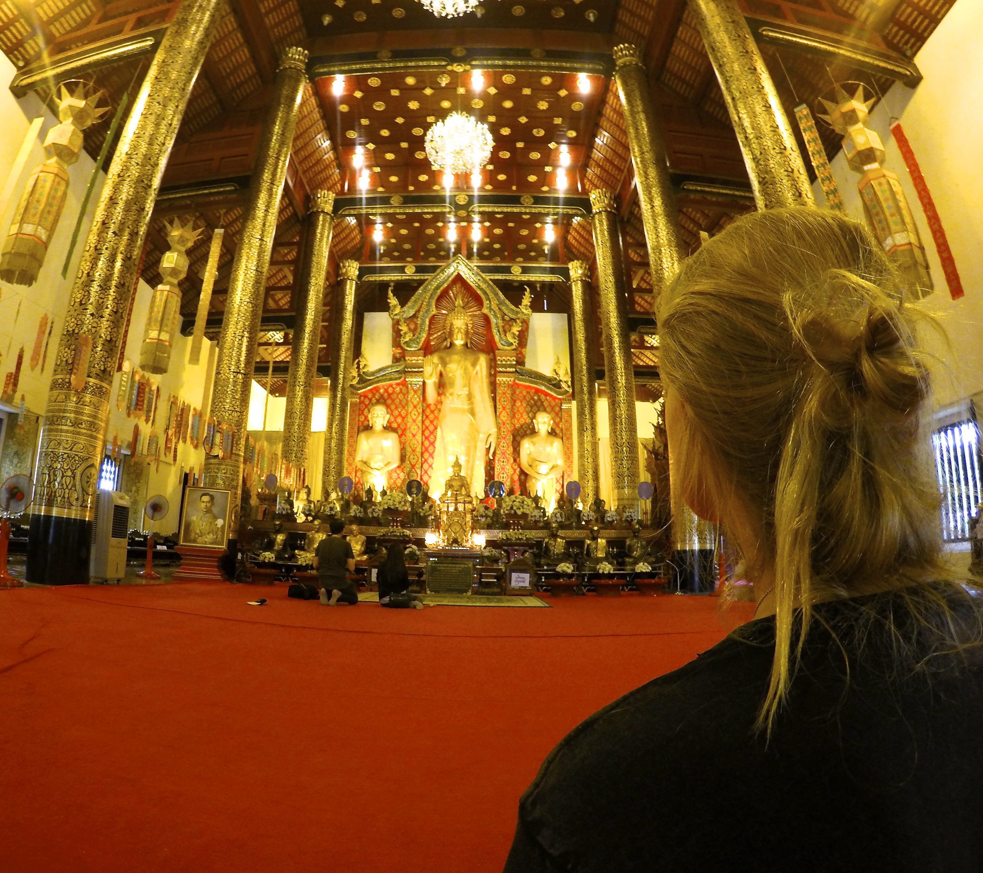 Observing the buddhists as they pay homage to the Triple Gem.