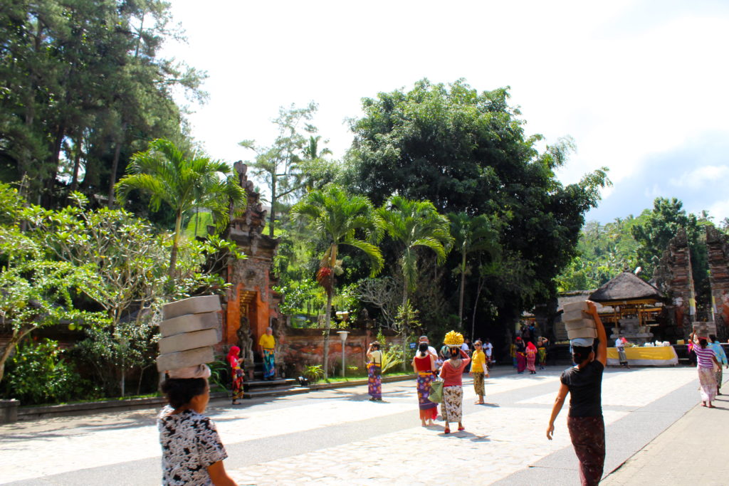 Local woman carrying building materials and fruit throughout the temple grounds.
